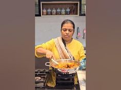 a woman cooking food in a pot on the stove