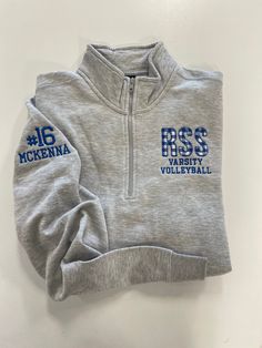 the back of a gray sweatshirt with blue letters on it and numbers printed on the sleeves