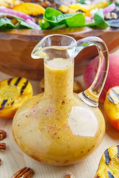 a glass bottle filled with liquid sitting on top of a table next to other fruit and vegetables