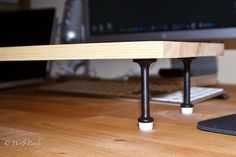 a wooden desk with a computer monitor and keyboard on it, next to a mouse pad