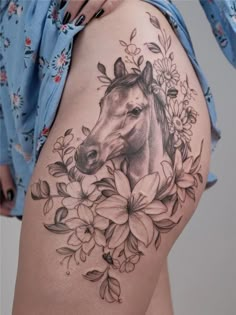 a woman's thigh with a horse and flowers on it