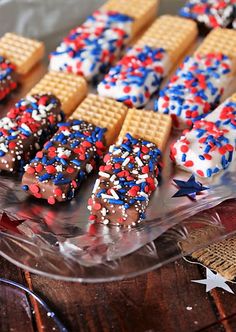 patriotic cookies and waffles are arranged on a clear plate with red white and blue sprinkles