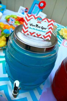 a blue cooler sitting on top of a table next to a red cup and other items