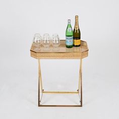 a table with wine glasses and bottles on it, sitting in front of a white background