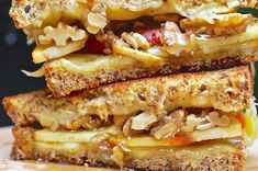 two grilled cheese sandwiches stacked on top of each other with fruit and nut toppings