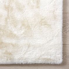 a white rug on top of a wooden floor next to a wood flooring board