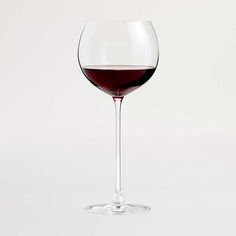 a wine glass filled with red wine on top of a table