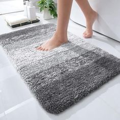 a person standing on top of a bathroom rug