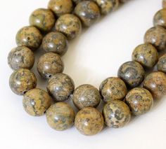 two strands of brown marble beads on a white surface with one strand in the middle