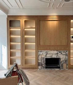 an empty living room with built in bookcases and a fire place on the wall