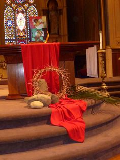 the altar is decorated with red cloths and decorations, including a wreath on top