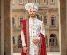 a man dressed in white and red is standing outside