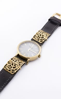 Wrist watch with gold-plated Arabic calligraphy clips. سألوني الناس عنك يا حبيبي Arabic Watch, Calligraphy Products, Lux Gifts, Arabic Lettering, Arabic Calligraphy Painting, Arabic Jewelry, Jewelry Photography Styling, Jewelry Casket, Art Jewelry Design