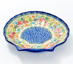 a blue and white bowl with floral designs on the rim, against a white background