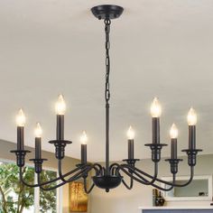 a chandelier with six lights hanging from the ceiling in a dining room area