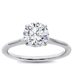 a round cut diamond ring on a white background