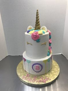 a three tiered cake decorated with an unicorn's horn