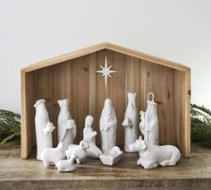 a nativity scene with figurines in the shape of people and animals on a wooden shelf