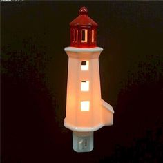 a red and white lighthouse light on a black background