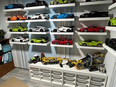 a room filled with lots of toy cars on shelves next to a wall mounted bookcase