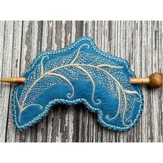 a wooden handle with a blue and white leaf design on the front, sitting on top of a wood surface