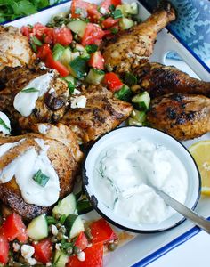 grilled chicken with greek salad and yogurt sauce on a platter, ready to be eaten