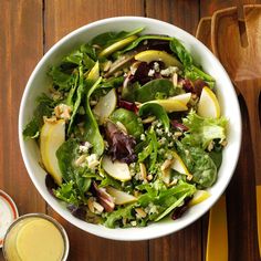 a white bowl filled with salad next to a glass of orange juice