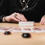 a woman sitting at a table with playing cards