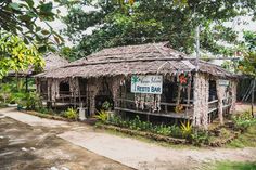 a small hut made out of rocks with plants growing on the roof and side walls