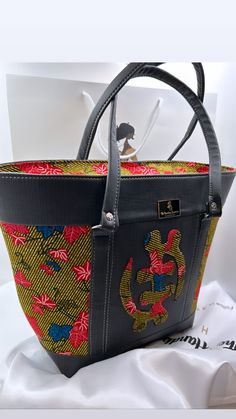 Our luxurious handmade handbags are made from vibrantly stunning wax print West African fabric, they're expertly and beautifully crafted handbags with vegan leather base and double stitched to ensure long durability and longevity in use. We are proud to say our luxurious handbags are eco-friendly and reduces your carbon footprint. All materials are locally sourced in Ghana, West Africa.  Our luxurious handbags are designed to keep everything safe inside with our full zipper closure 17.5"L x 13"H Luxury Multicolor Rectangular Bucket Bag, Designer Handmade Bags For Daily Use, Designer Handmade Multicolor Shoulder Bag, Designer Handmade Shoulder Bag For Daily Use, Designer Multicolor Handmade Bags, Designer Handmade Multicolor Bags, Multicolor Leather Tote Box Bag, Luxurious Handbags, Top Handle Bags