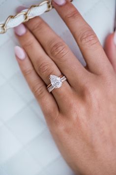 a woman's hand holding a diamond ring