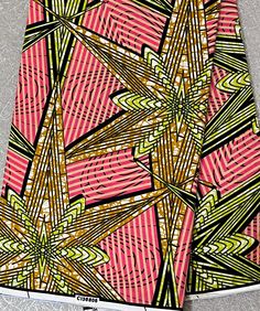 a pink and yellow abstract print fabric on a gray surface with white lines in the background