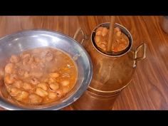 a metal bowl filled with beans next to a copper cup