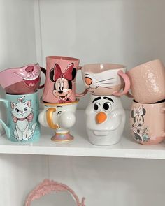 the shelves are filled with many disney mugs