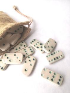 white dominos are scattered on the floor next to a drawstring bag with two bags full of them