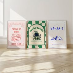 three books sitting on top of a hard wood floor next to a white wall and window