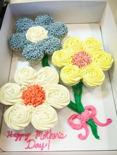 three cupcakes in a box decorated with flowers and the words happy mother's day