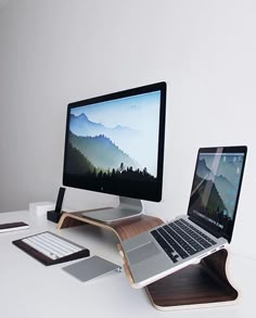 a desk with a laptop, monitor and keyboard on it