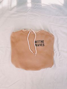 a brown bag with the words hit the waves on it sitting on a white sheet