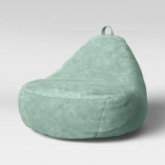 a green bean bag chair sitting on top of a white floor