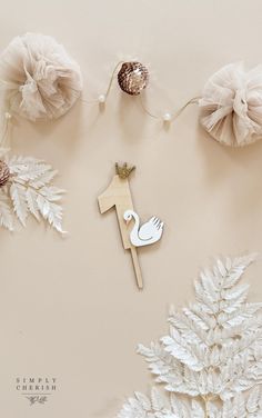 a wooden cross with a white dove on it surrounded by flowers and pineconi