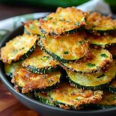 a bowl filled with cooked zucchini on top of a wooden table