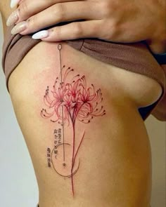 a woman's stomach with a flower tattoo on her side and the words written in chinese