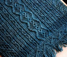 a blue knitted shawl sitting on top of a table