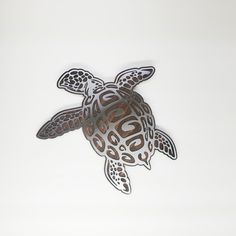 a close up of a sea turtle on a white background with an intricate cut out design