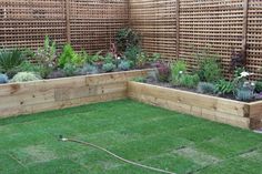 a garden area with grass and wooden fence