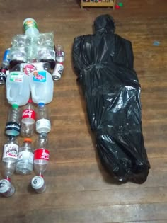 there are many plastic bottles on the floor next to a bag and a sleeping bag