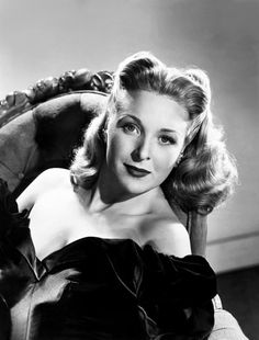 a black and white photo of a woman sitting in a chair