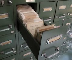 many file cabinets with files in them and some papers stacked on top of each other