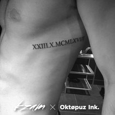 a black and white photo of a man's arm with roman numerals on it